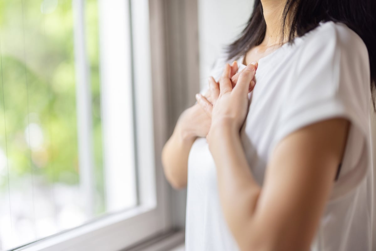Mano sobre el pecho — cuidado cardiovascular y prevención para pacientes y familiares
